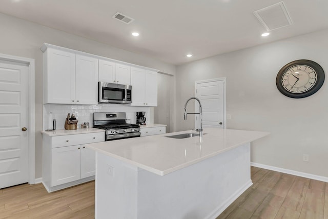 kitchen with a sink, light wood-style flooring, visible vents, and stainless steel appliances