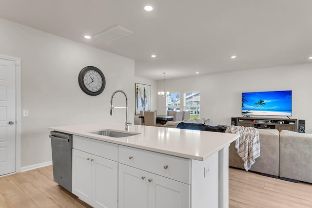 kitchen with a sink, light wood-style floors, dishwasher, and open floor plan