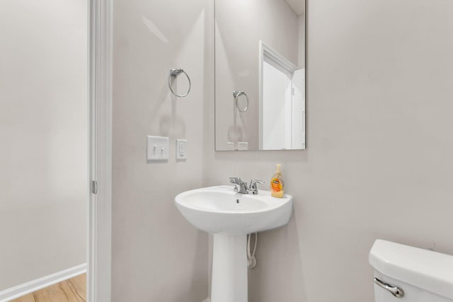 bathroom featuring baseboards, toilet, and wood finished floors