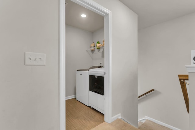 laundry room featuring light wood finished floors, laundry area, independent washer and dryer, and baseboards