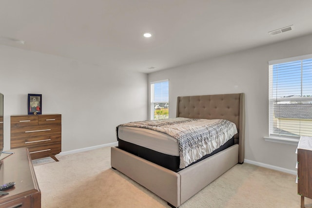 bedroom with visible vents, light colored carpet, and baseboards