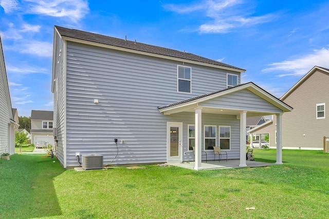 back of house featuring central air condition unit, a lawn, and a patio