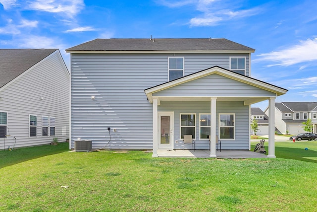 rear view of property featuring a lawn and a patio area