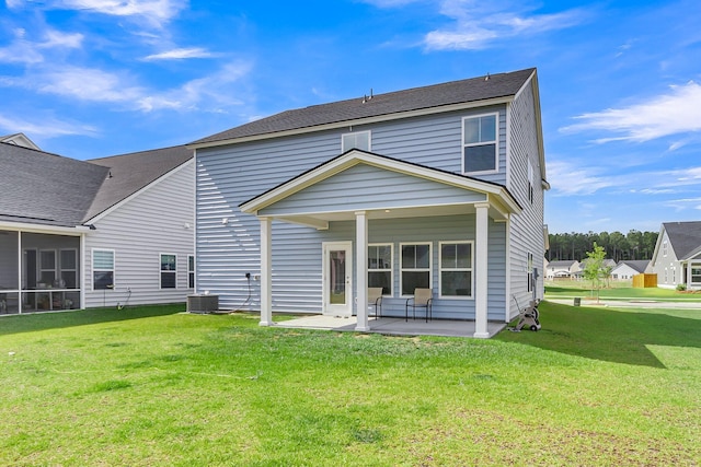 rear view of property with a patio, central air condition unit, and a lawn