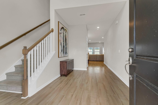 foyer with stairway, visible vents, baseboards, recessed lighting, and light wood-style floors