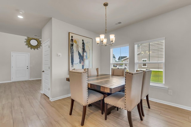 dining room with visible vents, baseboards, light wood-style floors, and a chandelier