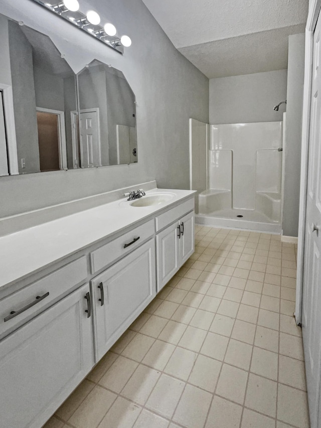 bathroom featuring a shower, a textured ceiling, vanity, and tile patterned flooring