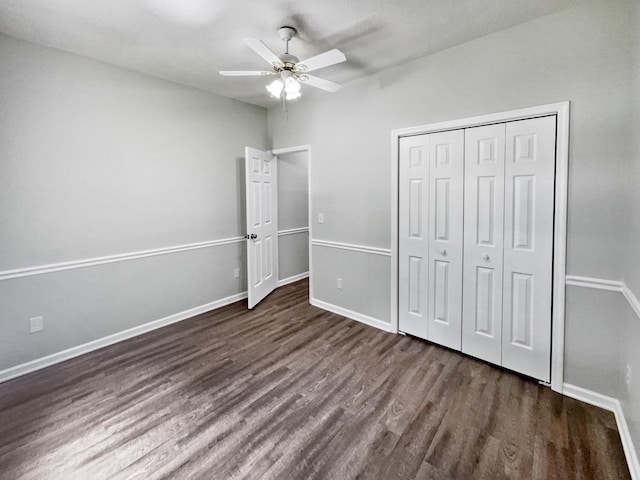 unfurnished bedroom featuring ceiling fan, a closet, and dark hardwood / wood-style flooring