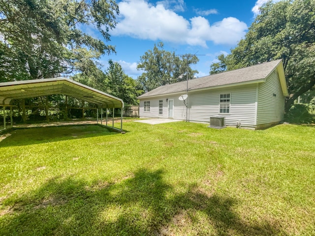 back of house featuring a lawn, central air condition unit, and a carport