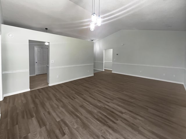 unfurnished living room featuring lofted ceiling and dark hardwood / wood-style floors