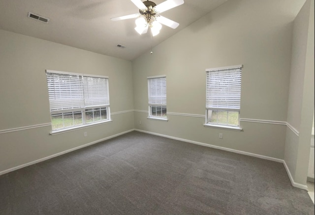 spare room featuring vaulted ceiling, ceiling fan, and dark colored carpet