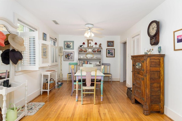 dining room with a ceiling fan, baseboards, and hardwood / wood-style flooring