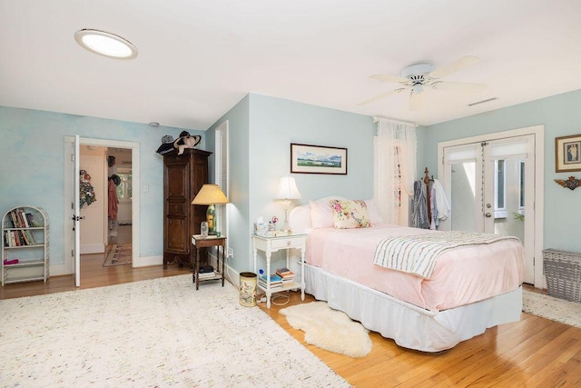 bedroom featuring wood finished floors, french doors, and baseboards