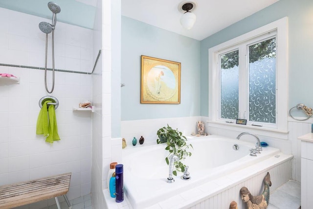 bathroom with a garden tub and a tile shower