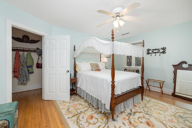 bedroom featuring wood finished floors, baseboards, and a ceiling fan
