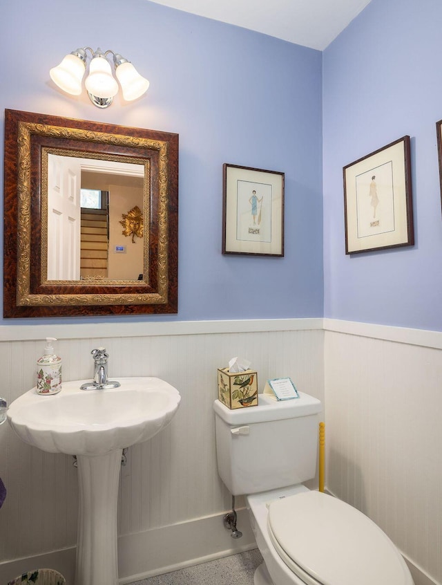 bathroom featuring a wainscoted wall and toilet