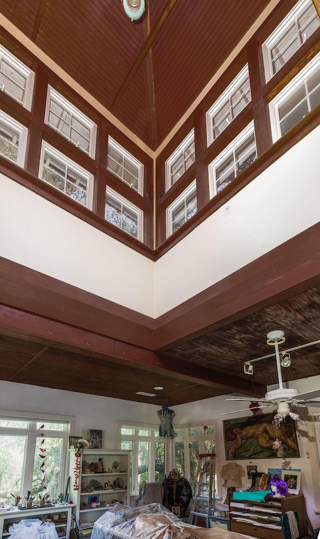 detailed view of a ceiling fan, wooden ceiling, and beamed ceiling