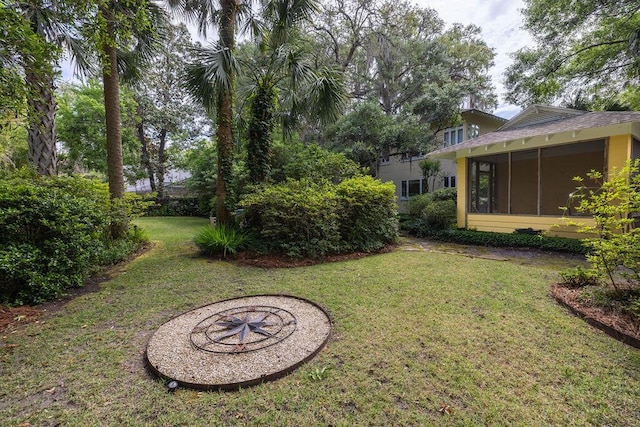 view of grassy yard featuring a sunroom