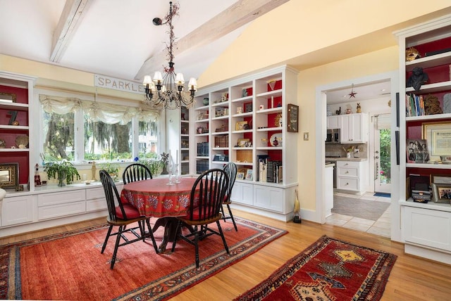dining space featuring vaulted ceiling, a chandelier, plenty of natural light, and light wood-style floors