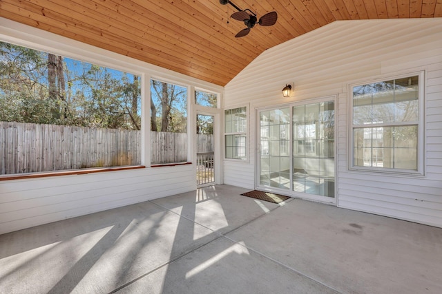 unfurnished sunroom featuring vaulted ceiling, a healthy amount of sunlight, ceiling fan, and wood ceiling