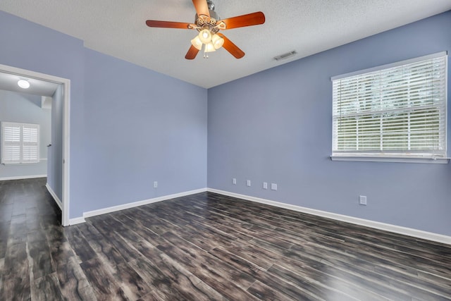 empty room featuring ceiling fan, dark hardwood / wood-style floors, and a textured ceiling