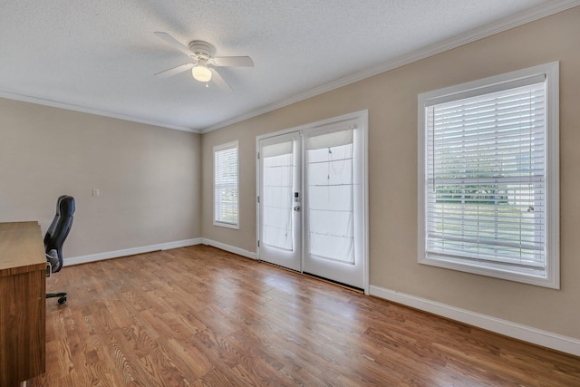 unfurnished office with crown molding, ceiling fan, a textured ceiling, and light hardwood / wood-style flooring