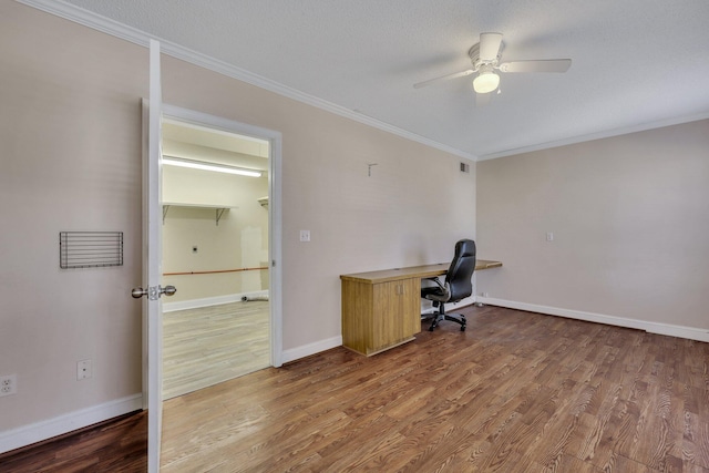 unfurnished office featuring crown molding, ceiling fan, hardwood / wood-style floors, and a textured ceiling