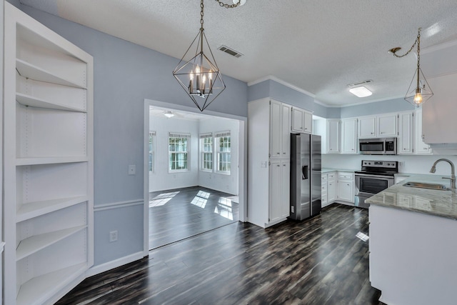 kitchen with stainless steel appliances, decorative light fixtures, and white cabinets