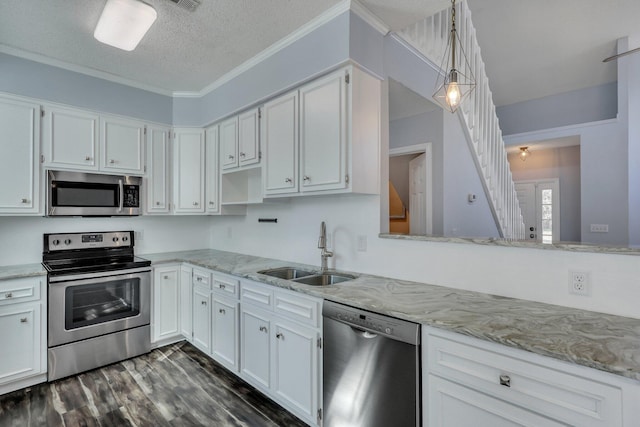 kitchen featuring sink, white cabinetry, a textured ceiling, pendant lighting, and stainless steel appliances