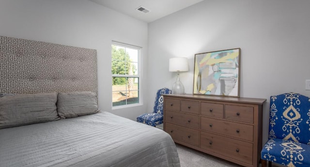 bedroom featuring visible vents and light carpet