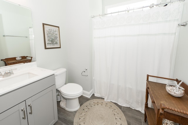 bathroom featuring vanity, hardwood / wood-style flooring, toilet, and walk in shower