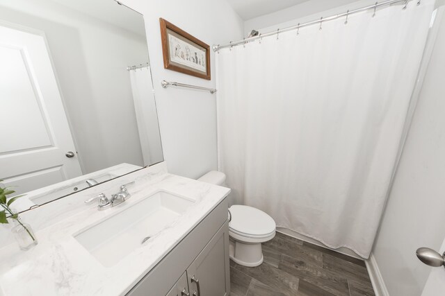 bathroom with vanity, hardwood / wood-style flooring, and toilet