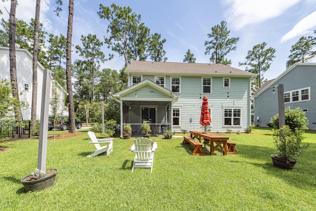 back of property with a sunroom and a yard