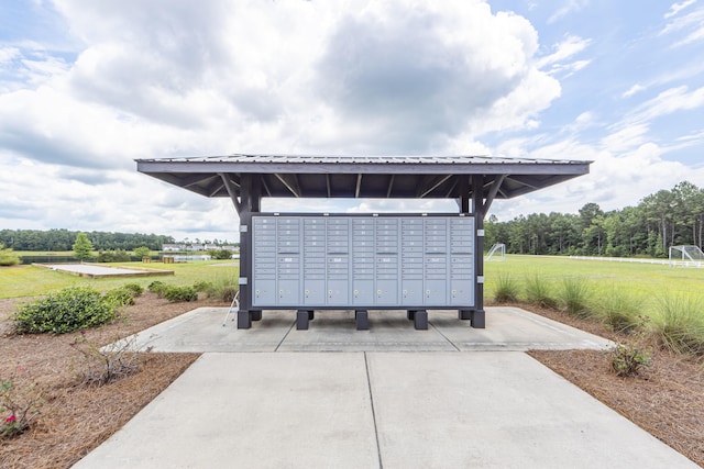 view of community with mail boxes and a yard