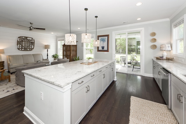 kitchen featuring white cabinets, dark hardwood / wood-style floors, decorative light fixtures, a kitchen island, and light stone counters