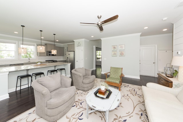 living room featuring a wealth of natural light, ceiling fan, crown molding, and dark hardwood / wood-style floors