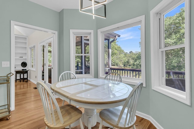 dining space with light wood finished floors and baseboards