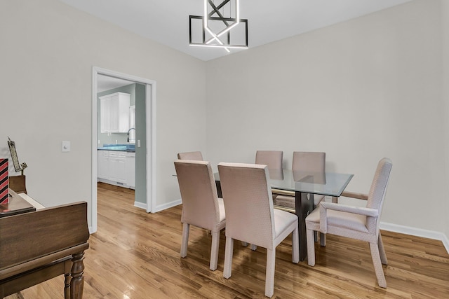 dining space featuring light wood-style floors and baseboards