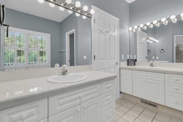 bathroom with tile patterned flooring and two vanities