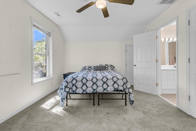 carpeted bedroom with lofted ceiling, a ceiling fan, ensuite bathroom, and baseboards