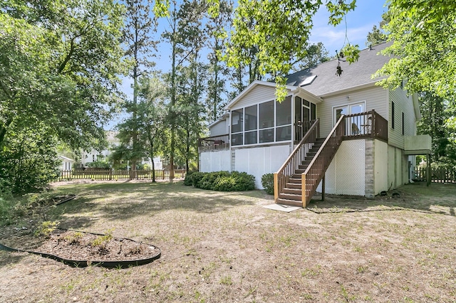 rear view of property with a sunroom, stairway, and fence