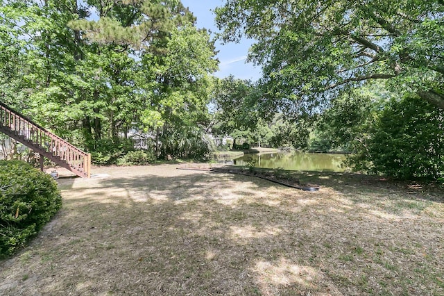 view of yard with stairway and a water view