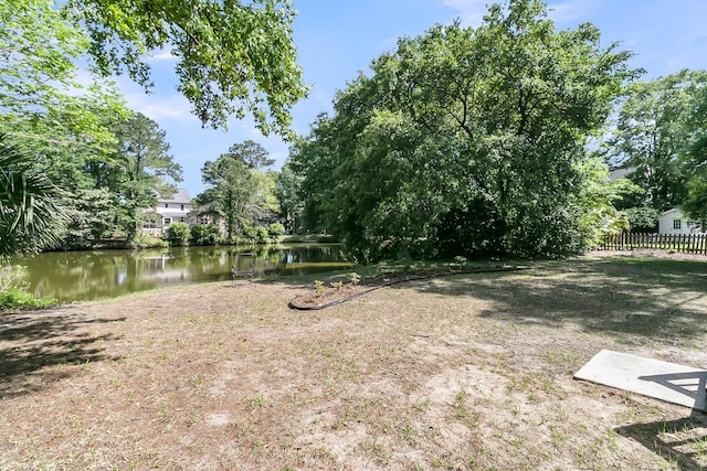 view of yard featuring a water view and fence