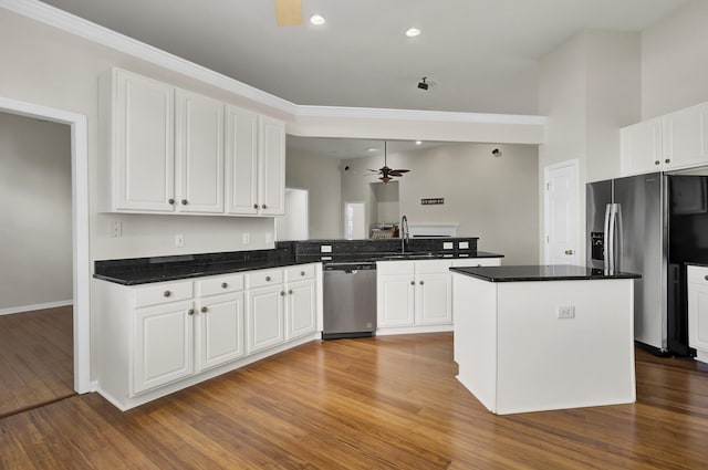 kitchen with white cabinetry, stainless steel appliances, kitchen peninsula, and ceiling fan