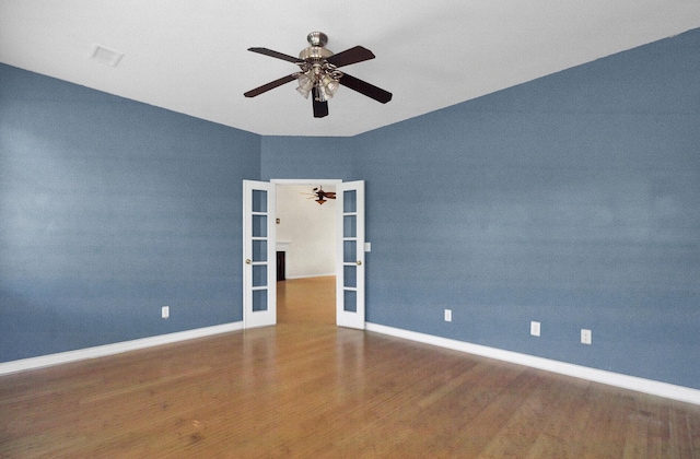 unfurnished room featuring dark wood-type flooring, french doors, and ceiling fan