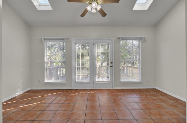 interior space featuring ceiling fan, tile patterned floors, and a skylight