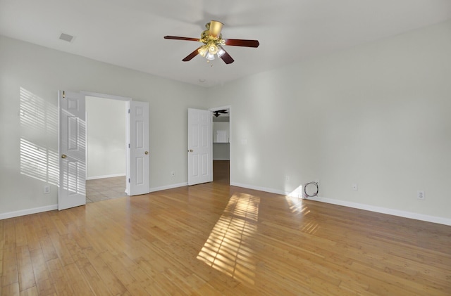 empty room with ceiling fan and light hardwood / wood-style floors