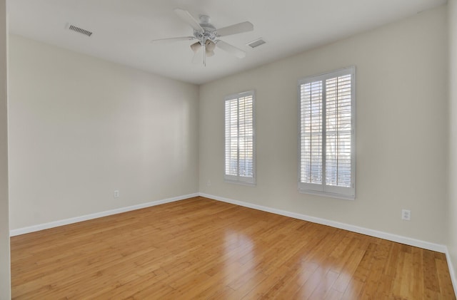 empty room with ceiling fan and hardwood / wood-style floors