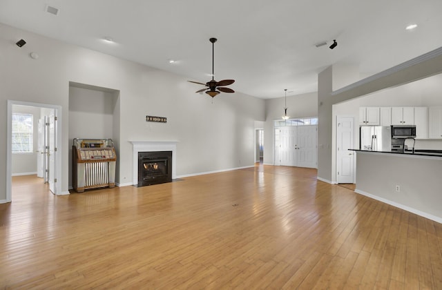 unfurnished living room featuring ceiling fan and light hardwood / wood-style floors