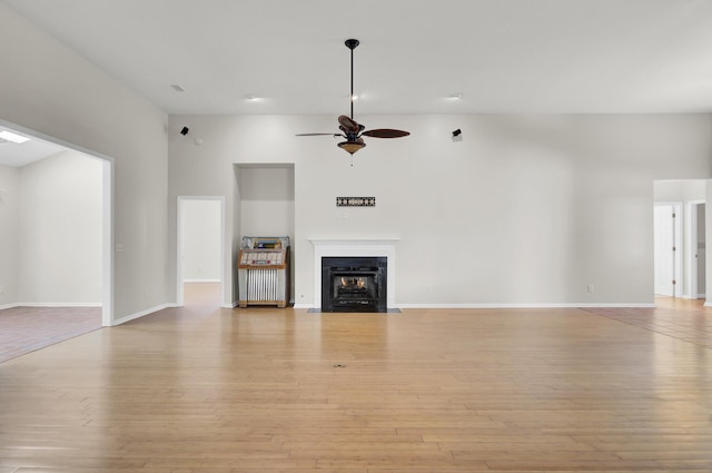 unfurnished living room featuring ceiling fan and light hardwood / wood-style flooring